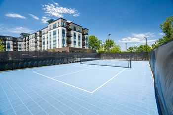 a tennis court with a building in the background